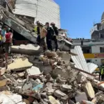 Rescue workers search through collapsed buildings after a magnitude 7.4 earthquake struck Colombia