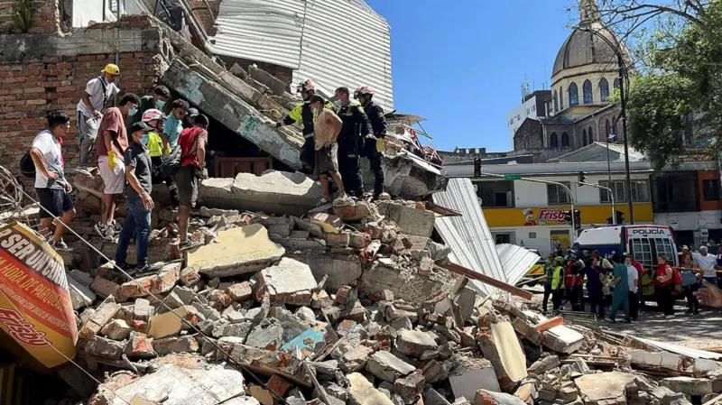 Rescue workers search through collapsed buildings after a magnitude 7.4 earthquake struck Colombia