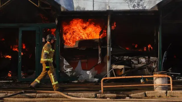 Firefighters battle flames at a Kyiv book market after a Russian strike