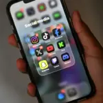 Teenager using a smartphone as New Zealand proposes a social media ban for children under 16