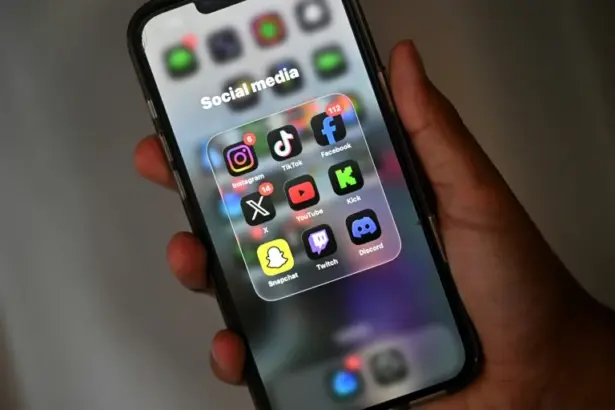 Teenager using a smartphone as New Zealand proposes a social media ban for children under 16