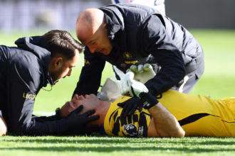 Chelsea goalkeeper Emiliano Martinez receiving medical treatment after colliding with Everton defender Jarrad Branthwaite